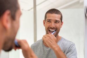 Man brushing teeth to avoid West Bloomfield emergency dentist