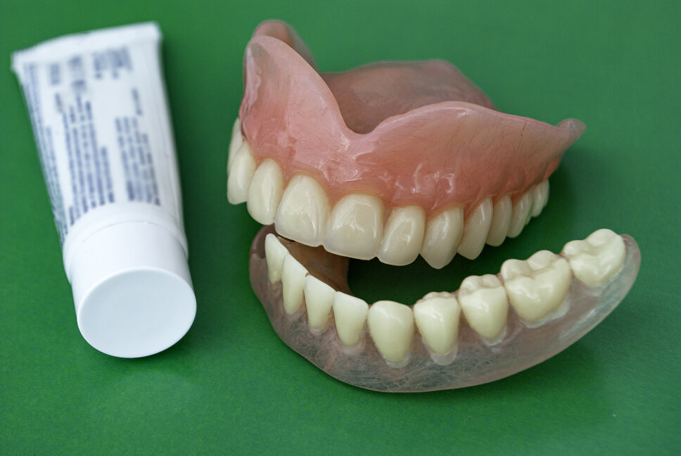 dentures next to tube of adhesive